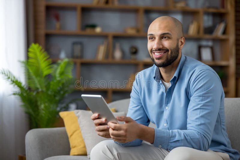 Smiling man communicating remotely using digital tablet at home stock images