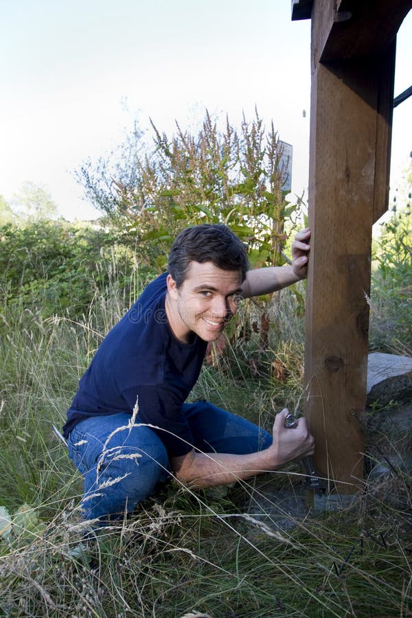 Smiling Man Fixing House - Vertical