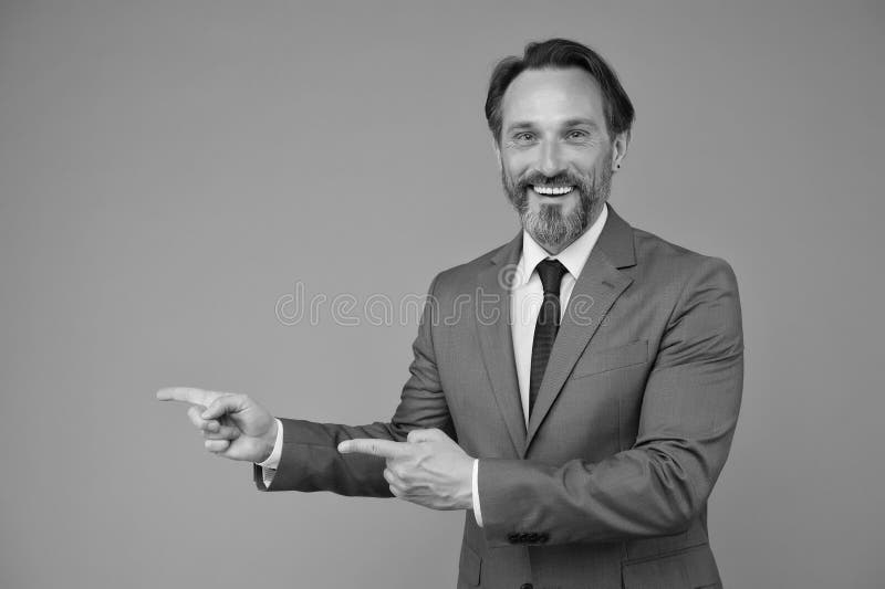 Smiling man good looking businessman pointing copy space, choose direction concept stock images