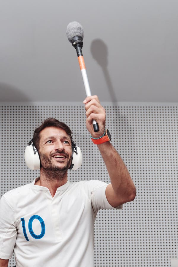 A Smiling Man Holding a Mace with Protection in His Ears Stock Photo Image of protection