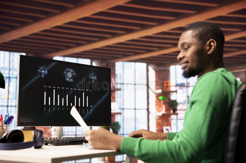 Smiling man in home office using financial application UI on PC screen royalty free stock photos