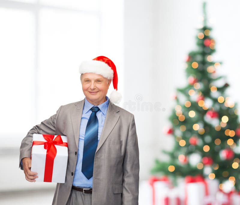 Smiling man in suit and santa helper hat with gift