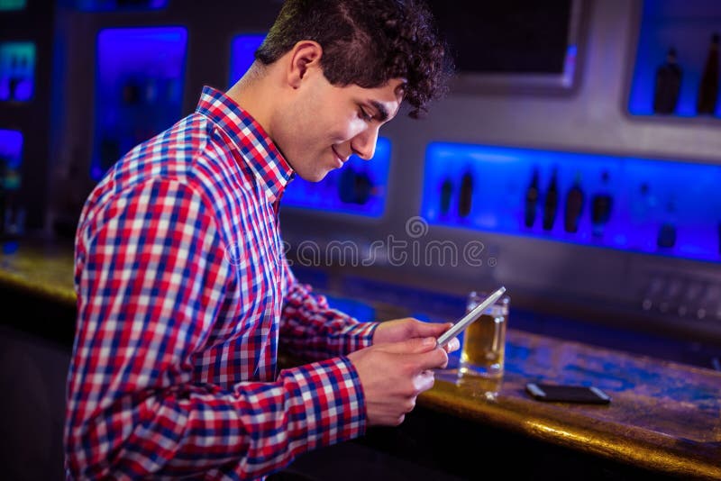 Smiling man using digital tablet by bar counter stock photography
