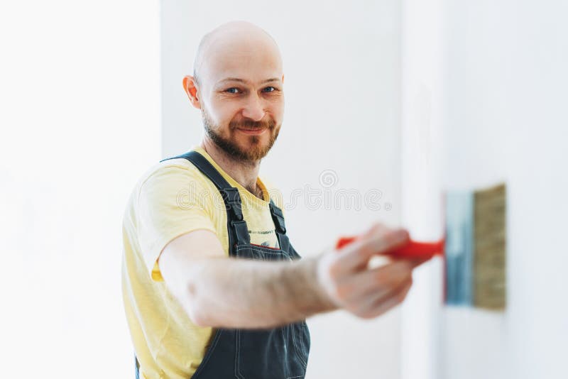 Man Worker in Overalls Do Repair Glue the Walls Under the Wallpaper or  Primer on Wall Selective Focus Stock Photo - Image of building, closeup:  179423170