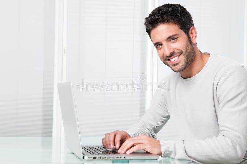 Smiling man working on laptop stock image