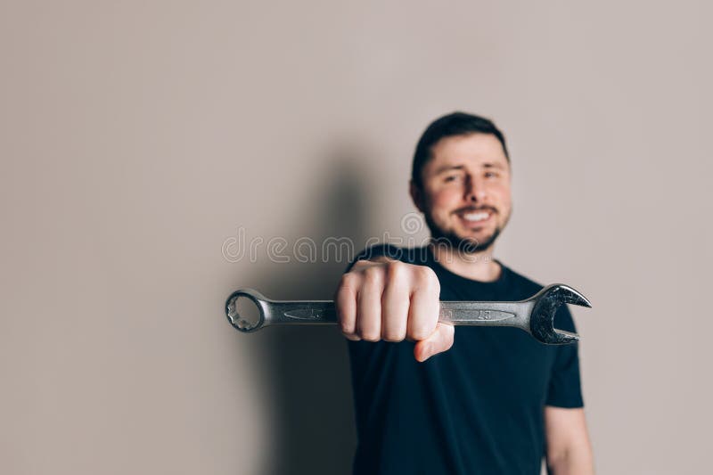 Smiling man with wrench in one hand stock photography