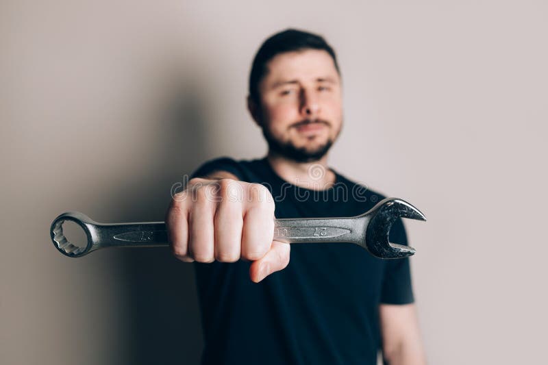 Smiling man with wrench in one hand stock photos