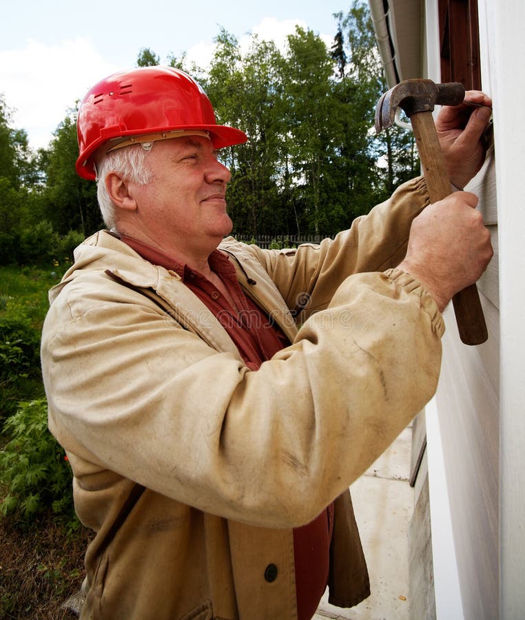 Smiling mature master with hammer