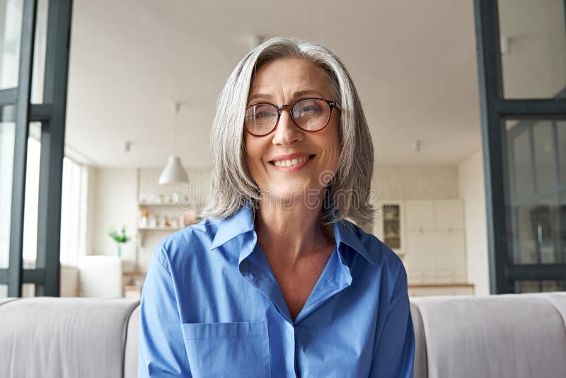 Smiling mature older woman looking at camera, webcam headshot.