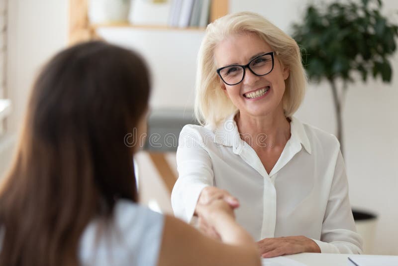Smiling middle-aged businesswoman handshake partner after successful negotiation stock image Smiling middle-aged businesswoman handshake partner after successful negotiation stock image