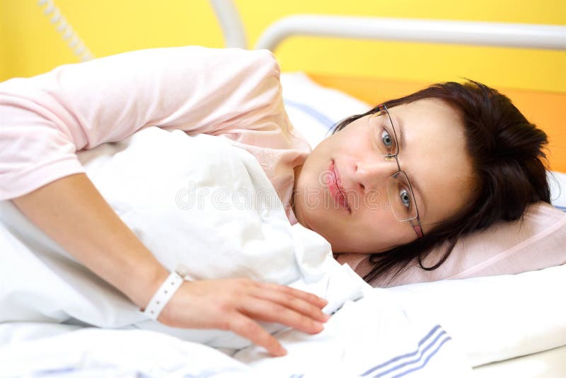 Smiling middle-aged woman lying in hospital