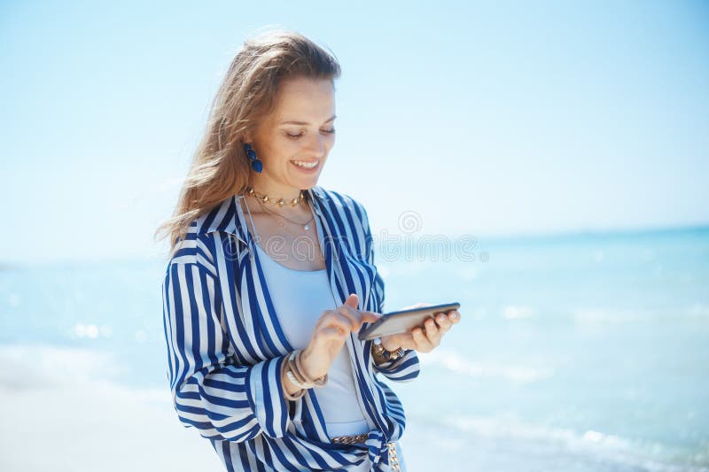 Smiling Modern Woman on Beach with Smartphone Stock Photo Image of