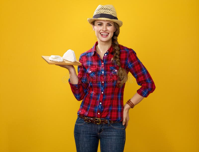 Smiling modern woman farmer showing trey with soft white cheese