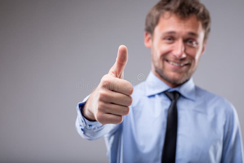Smiling motivated man giving a thumbs up royalty free stock photos