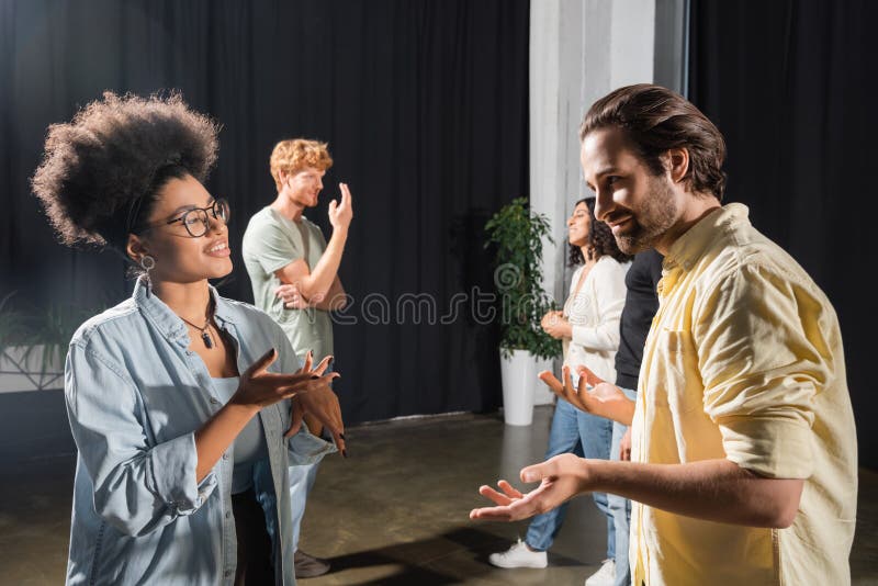 Smiling multiethnic actors gesturing during conversation royalty free stock image