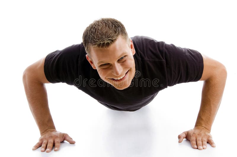 Smiling muscular male doing push ups