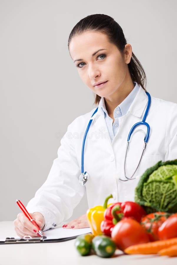 Smiling nutritionist writing medical prescriptions