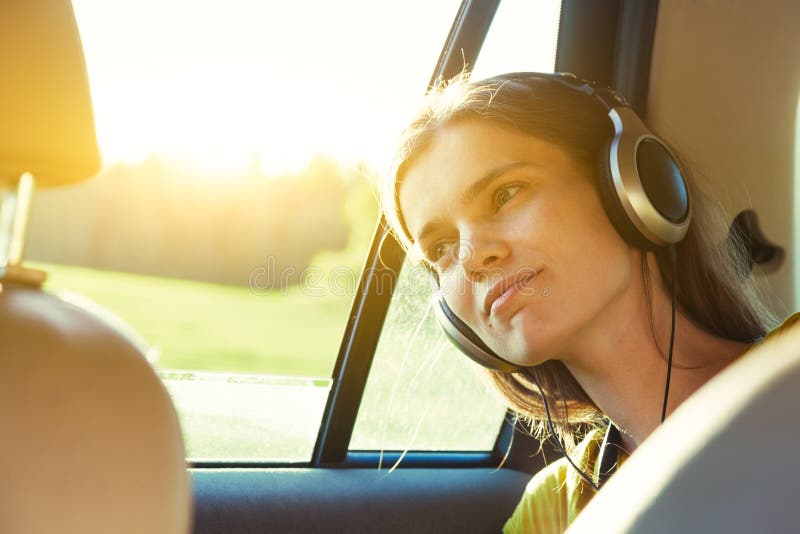 Smiling pretty girl listening to music with headphones moving in