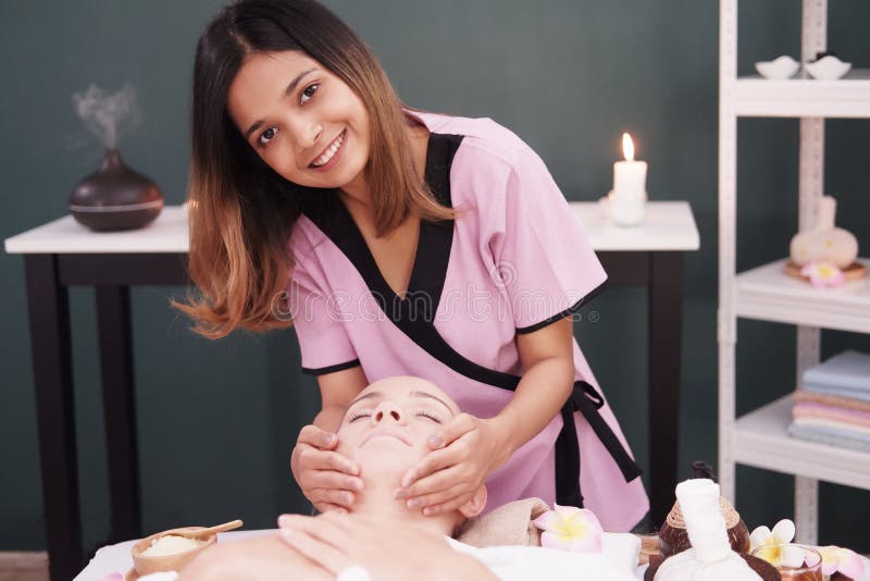 Chinese Woman Massage Therapist Giving A Treatment To An Attractive Blond Client On Massage