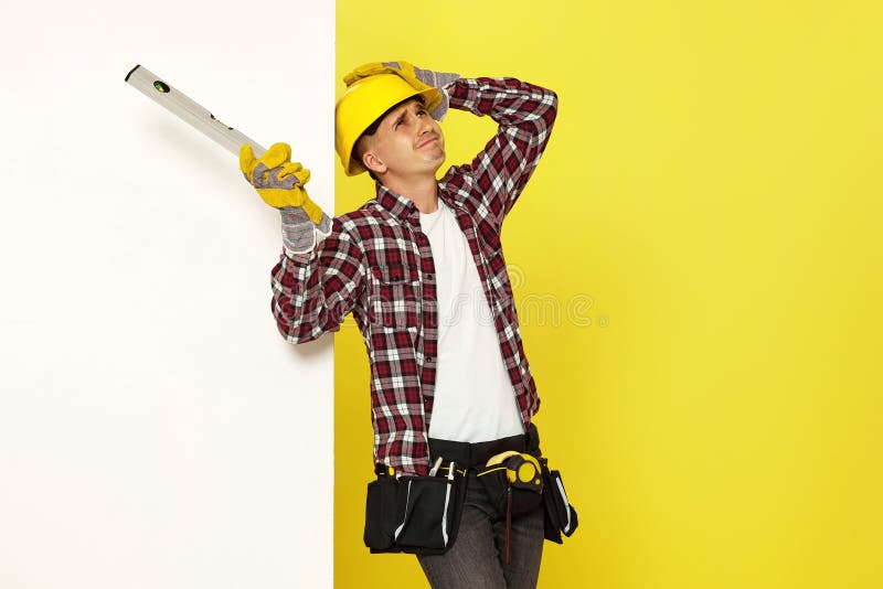 smiling professional builder in work clothes in helmet with level . stock photography