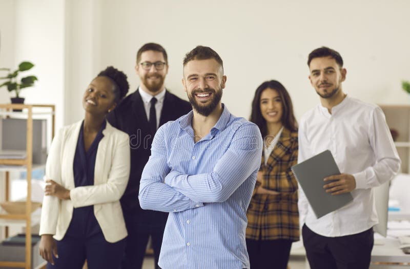 Happy smiling handsome caucasian manager or team leader standing with employees