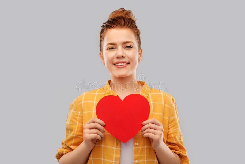 Smiling red haired teenage girl with heart