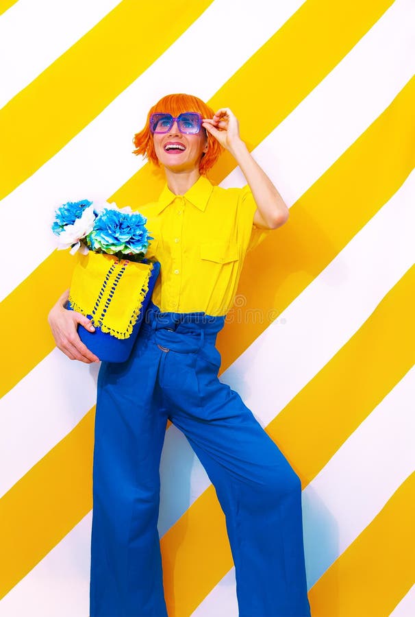 Smiling Retro Lady on trend striped yellow background with flower arrangement in her hands. Minimal spring summer concept