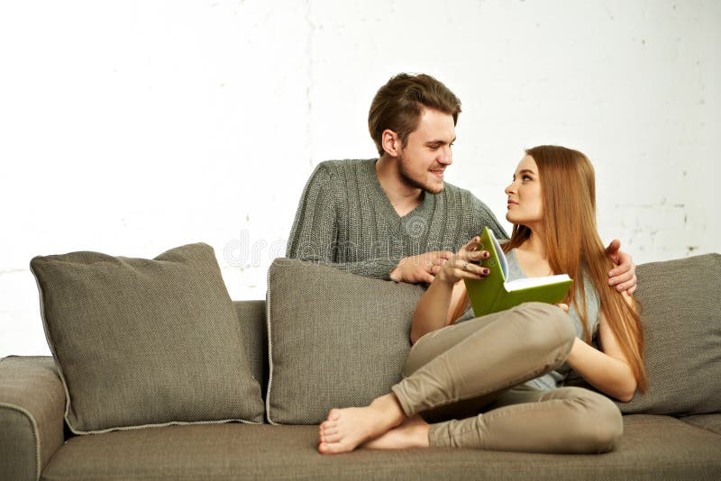 Smiling Romantic Couple With Book Talking on sofa