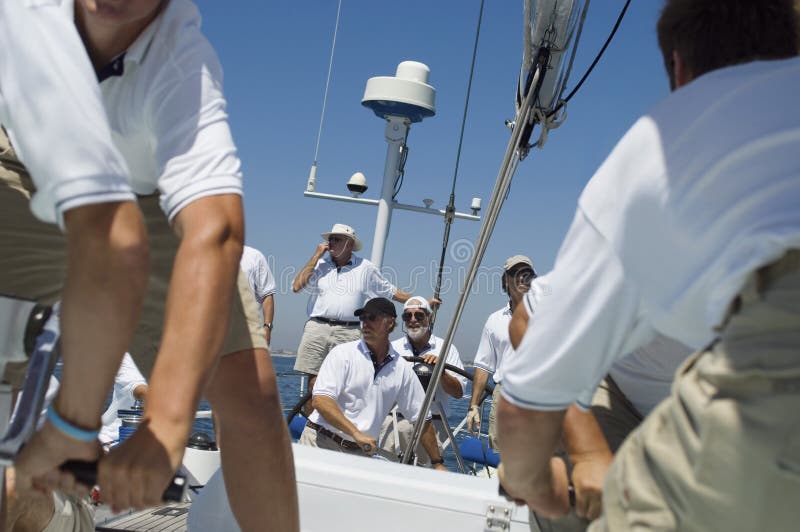 Smiling Sailor With Crew On The Sailboat Deck