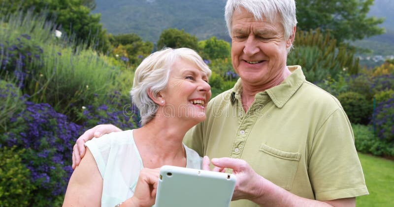 Senior couple using digital tablet in garden