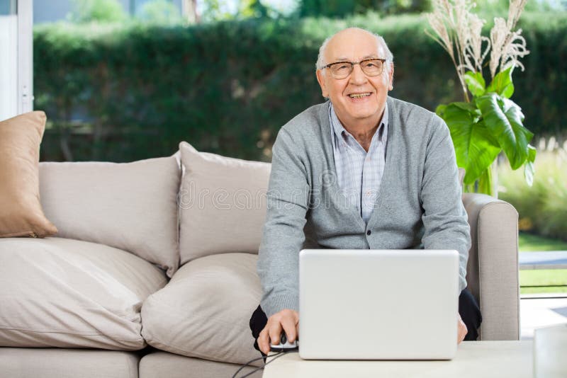 Smiling Senior Man With Laptop At Nursing Home