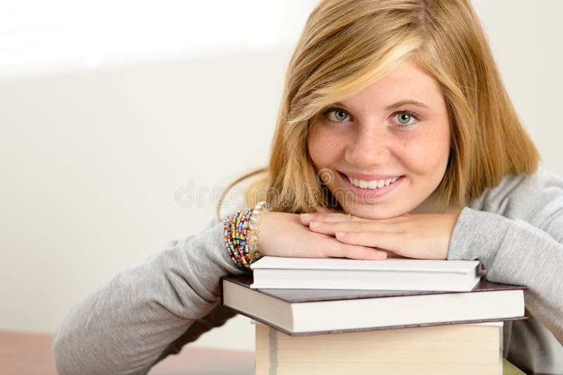 Smiling student teenager leaning head on books stock photography Smiling student teenager leaning head on books stock photography