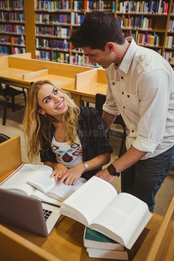 Smiling students working together while sitting at table stock photos Smiling students working together while sitting at table stock photos