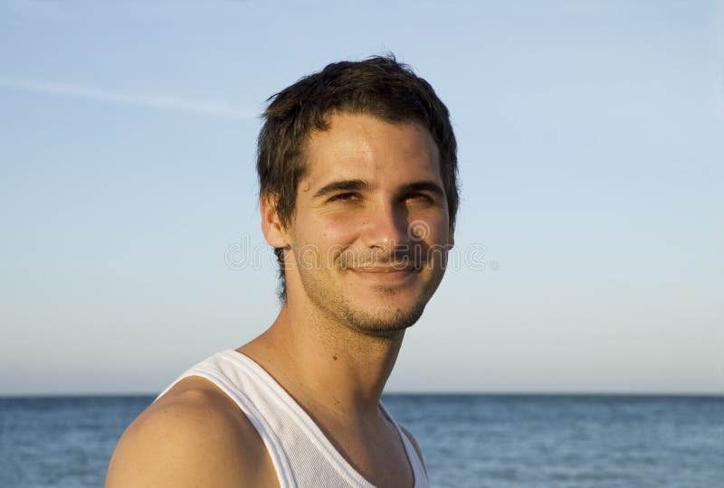 Mladí šťastný muž na tropické pláži na pozadí.