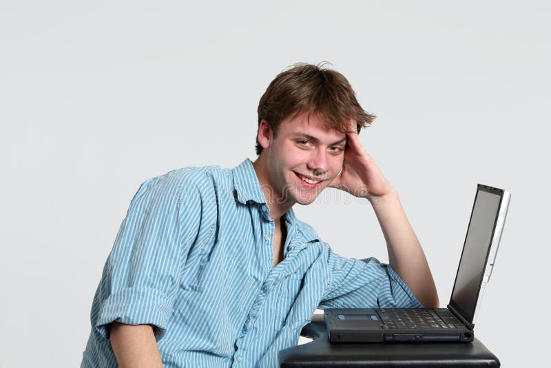 Smiling teen boy at computer royalty free stock photo