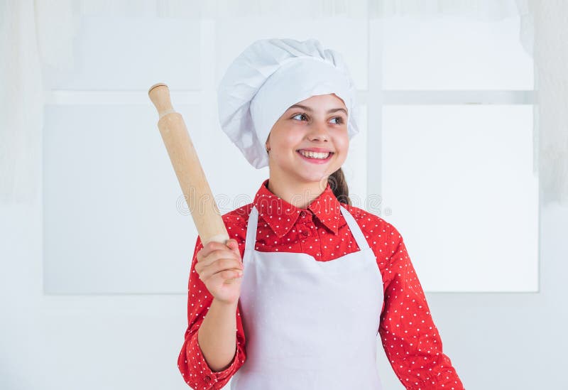 smiling teen girl in chef uniform cooking and baking, bakery