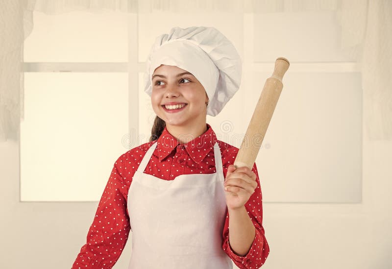 smiling teen girl in chef uniform cooking and baking, bakery