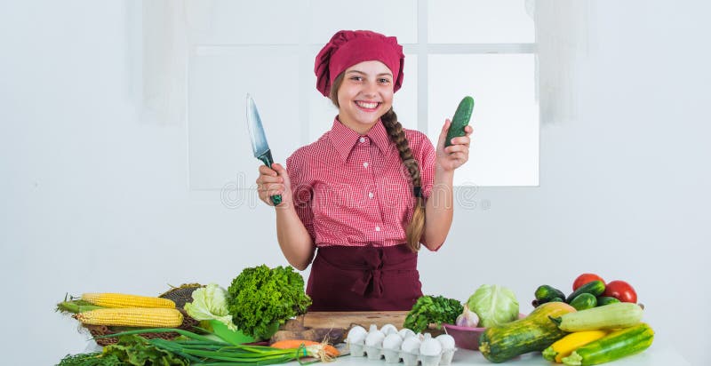 smiling teen girl in chef uniform cooking vegetables, vitamin