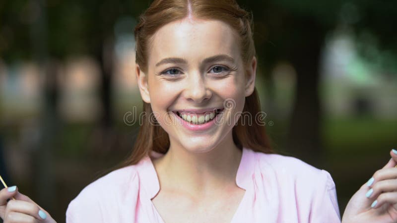 Smiling teen girl closing eyes with paper hearts, having fun and fooling around