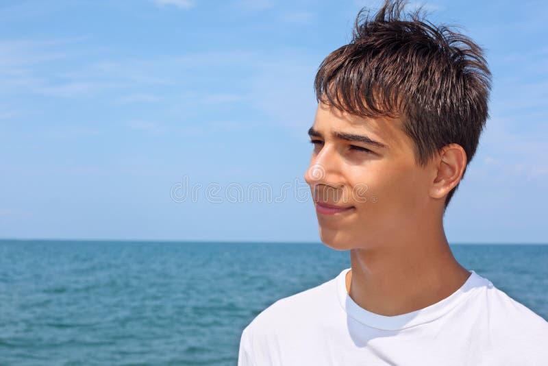 Ragazzo contro il mare, cercando in lontananza, estate.