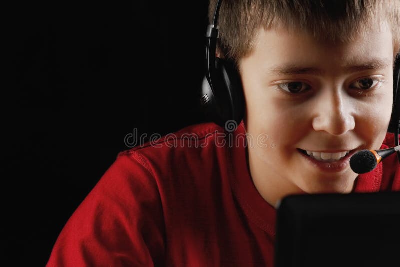 Smiling teenager playing on laptop stock photo