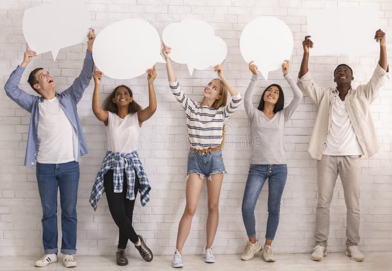 Smiling teenagers looking at empty speech bubbles above