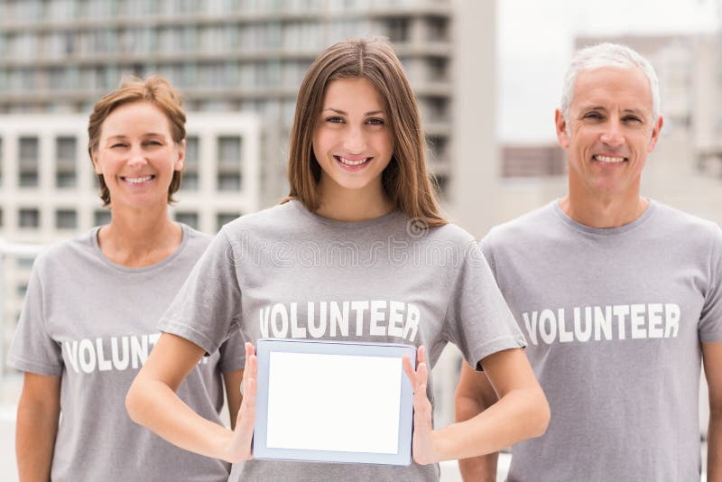 Smiling volunteers showing blank tablet