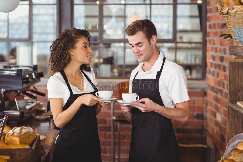 Smiling Waiter and Waitress Holding Cup of Coffee Stock Photo Image