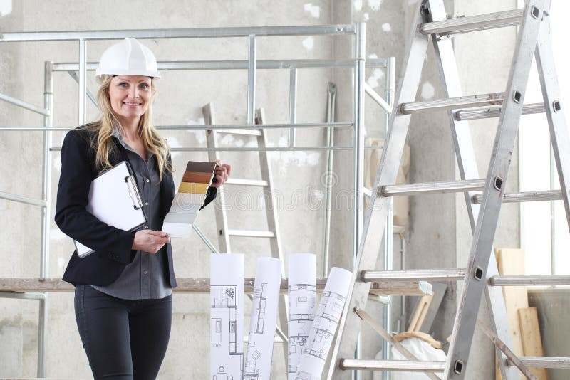 Smiling woman architect or construction interior designer with wooden color swatches palette chooses the color for the windows stock photos