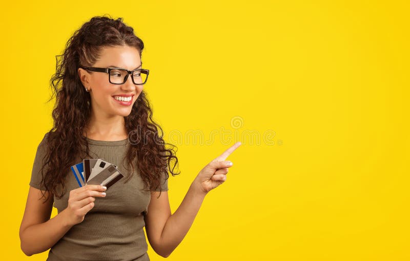 Smiling woman with credit cards pointing away royalty free stock image Smiling woman with credit cards pointing away royalty free stock image