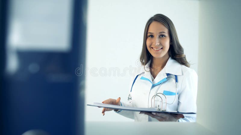 Smiling woman doctor taking folder at hospital