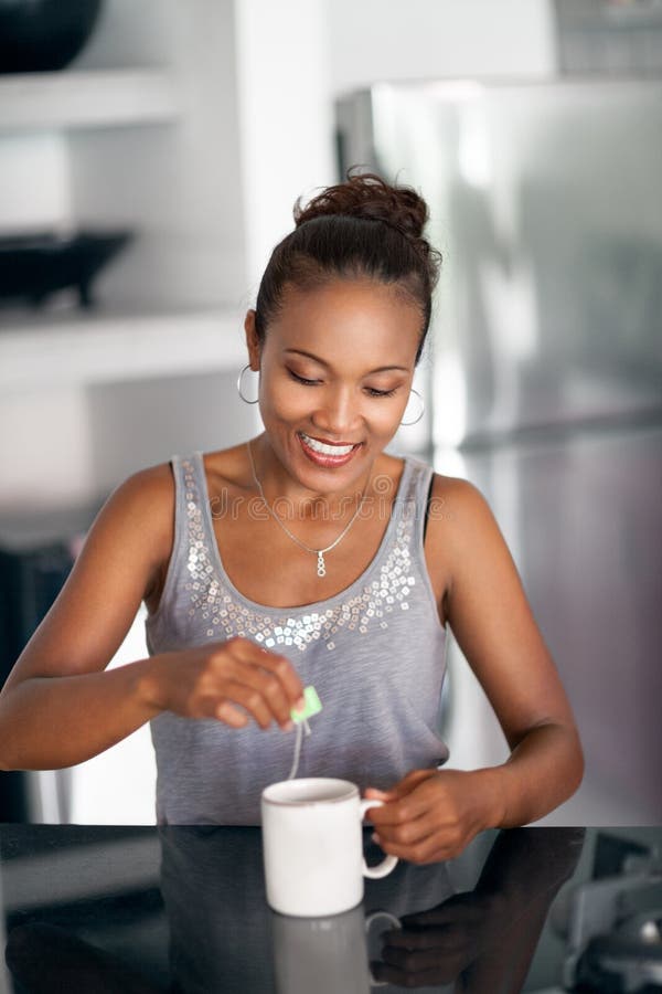 Smiling woman drinking tea in kitchen stock image Smiling woman drinking tea in kitchen stock image