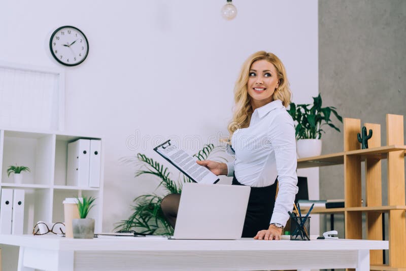 Smiling woman holding documents stock photography