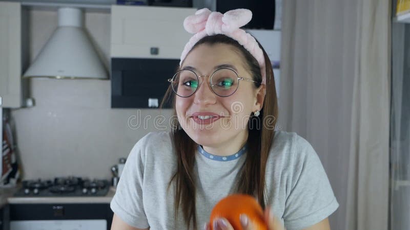 Smiling woman juggles fruits in the kitchen. Funny positive video.